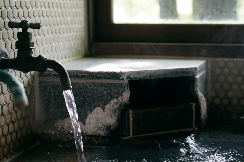 Running faucet beside a window, plumbing water source